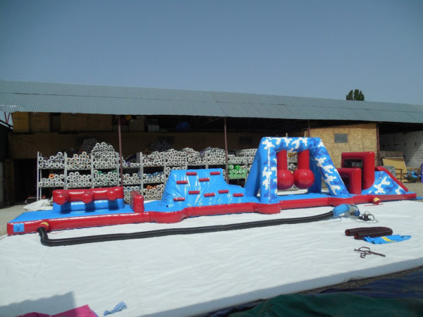 Parcours gonflable piscine avec toboggan aquatique.