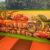 Château gonflable toboggan dinosaure avec décoration.