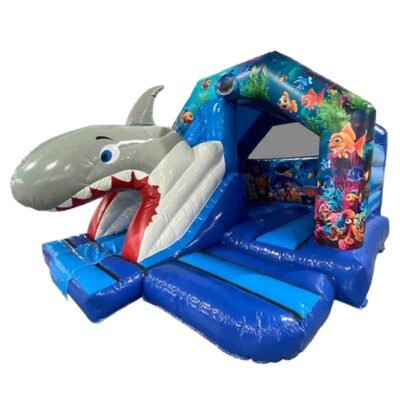 Château gonflable toboggan requin très visuel. Les enfants glissent par la gueule du requin ouverte